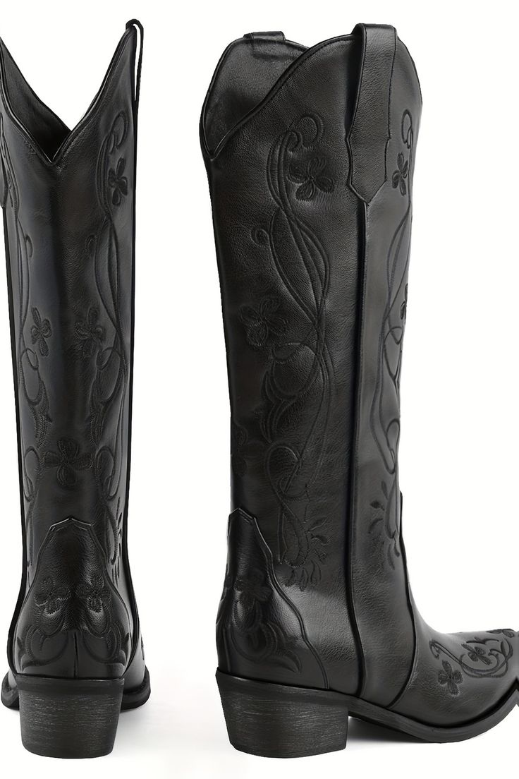 Pair of black cowboy boots with floral embroidery on a white background