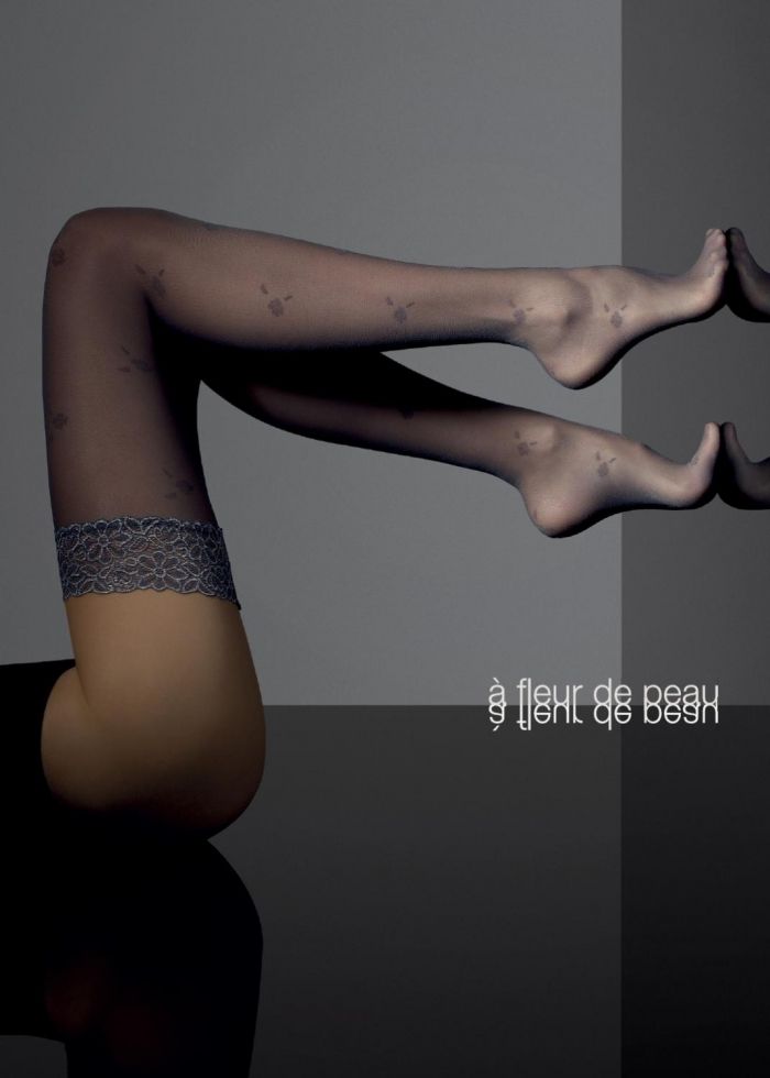 Woman's legs in patterned stockings with lace trim, studio shot