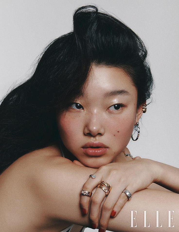 Woman with long black hair and jewelry posing for a portrait