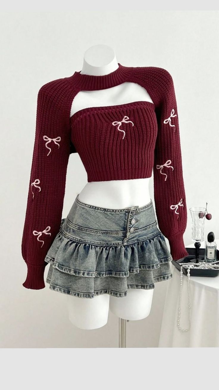 Mannequin wearing a maroon cropped sweater with bows and a ruffled denim skirt