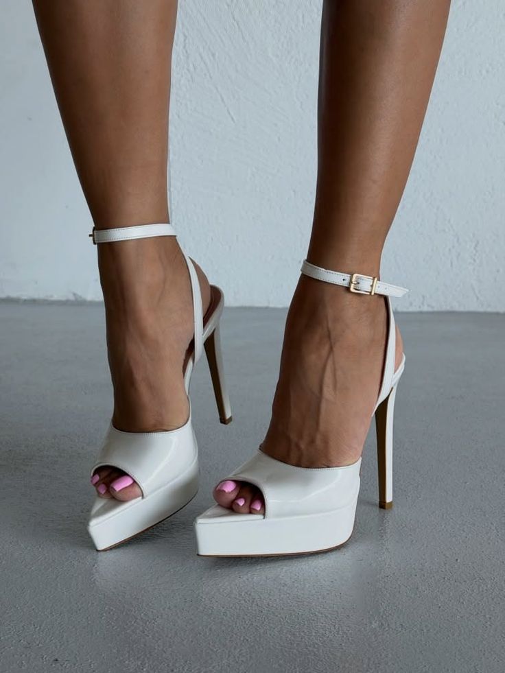 Woman's feet in white platform high heels with pink nail polish