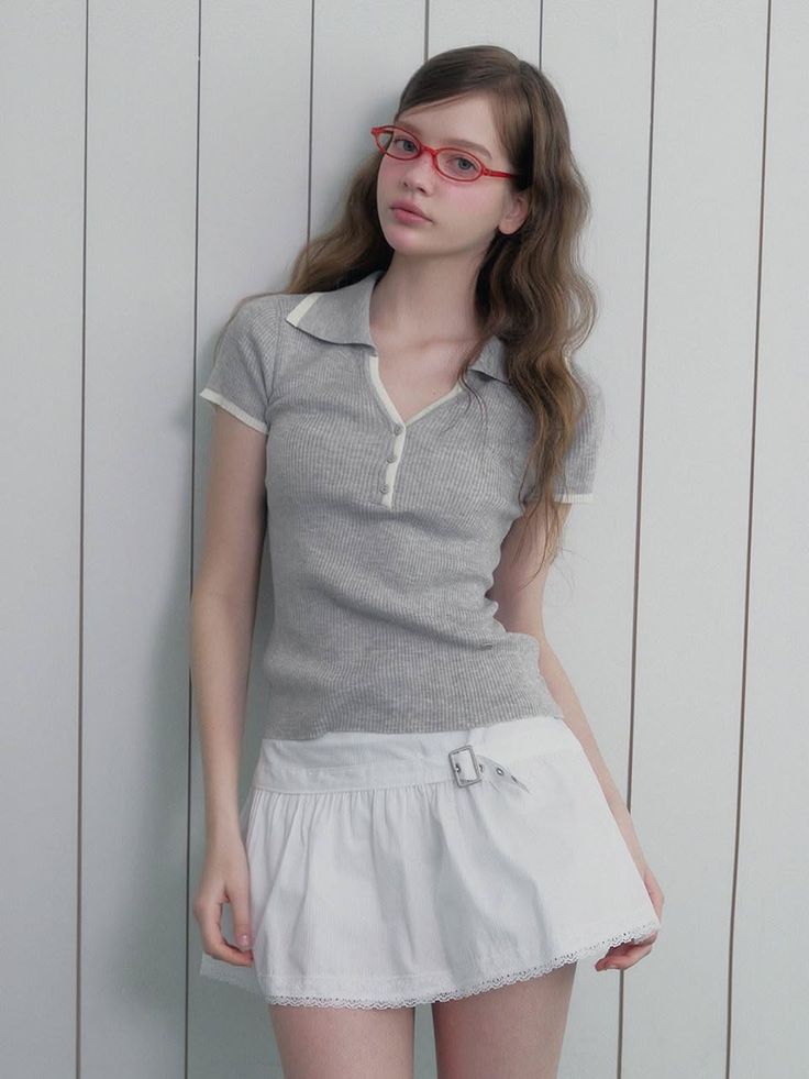 Woman with long hair and red glasses wearing a polo shirt and mini skirt