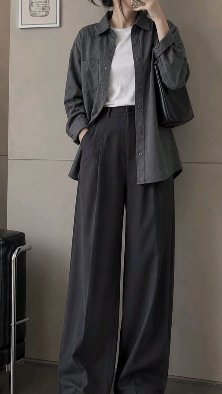 Person in dark wide-leg pants and an oversized shirt with a white t-shirt