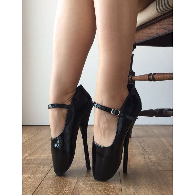 Person wearing black patent leather ballet heels while sitting on a chair