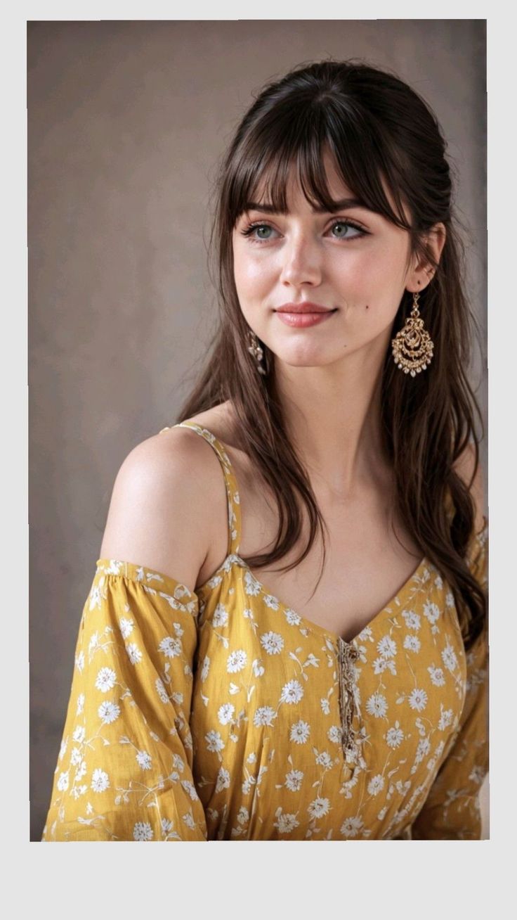 Woman with long hair and bangs wearing a yellow floral off-shoulder dress