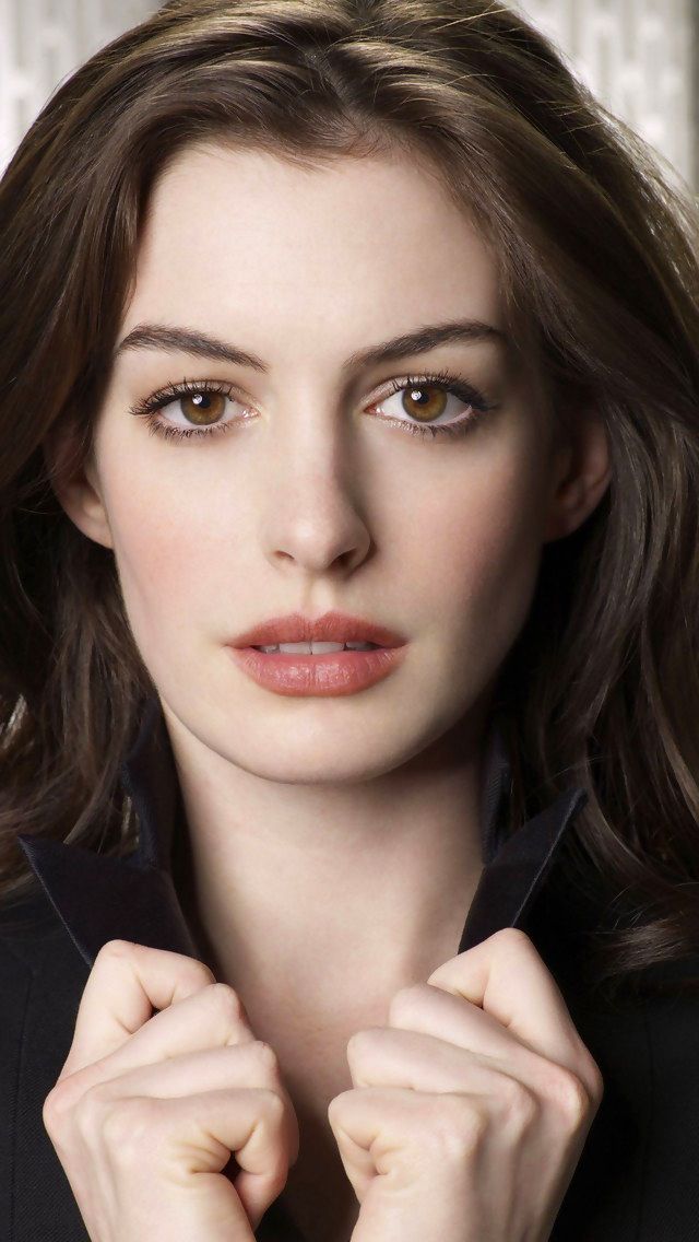 Woman with long brown hair and brown eyes holding her collar