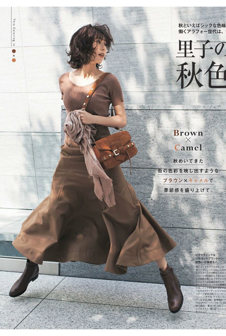 Woman with short hair in a brown top and long skirt, posing outdoors