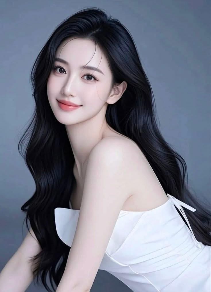 Woman with long black hair wearing a white strapless dress