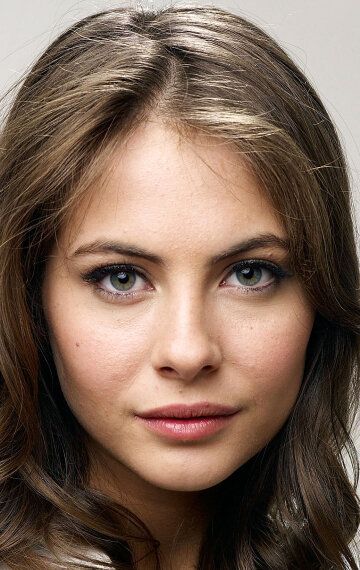Close up portrait of a woman with long brown hair and green eyes