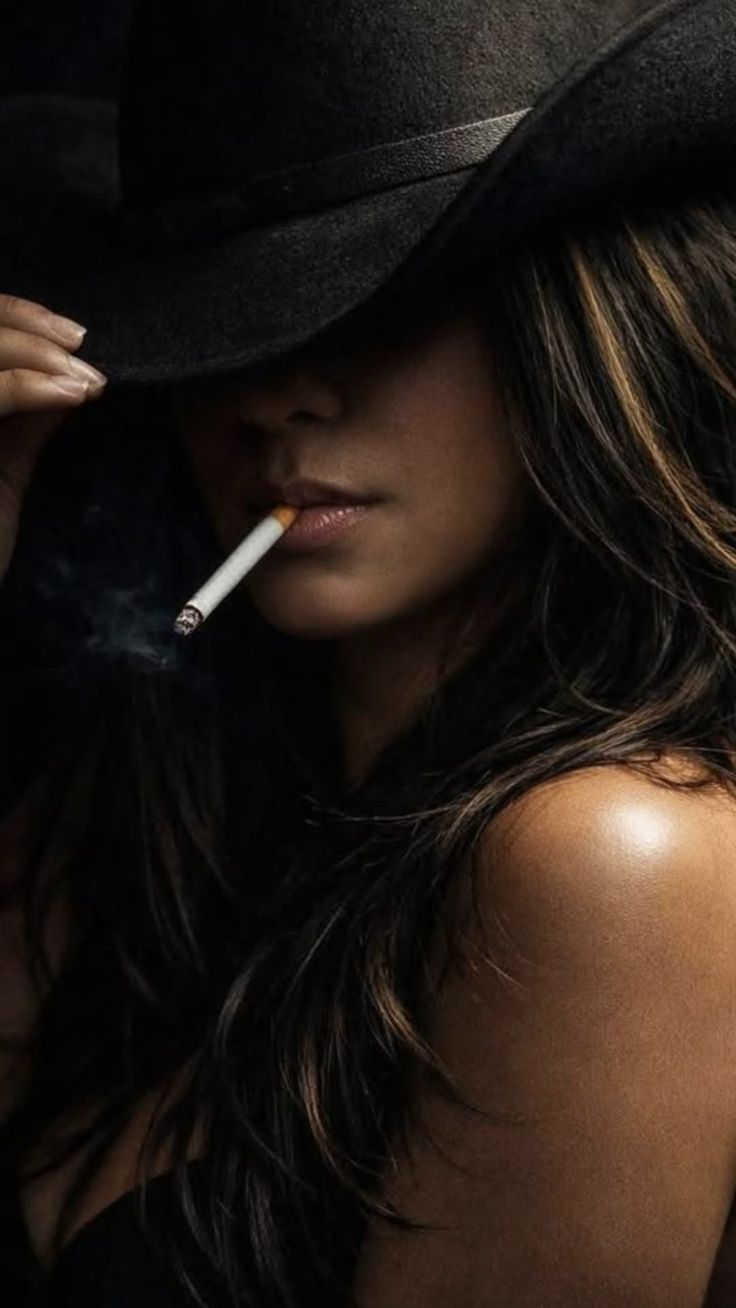 Woman in a black hat with a cigarette, dramatic lighting on her shoulder