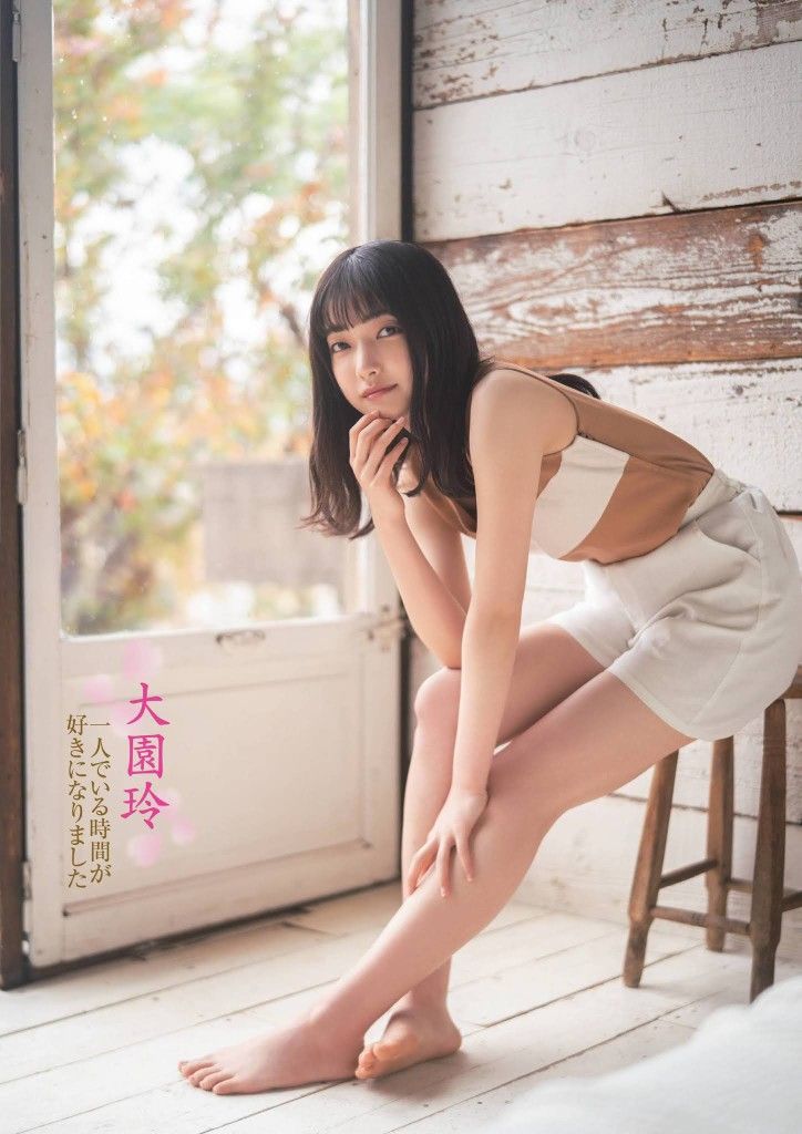 Woman with short dark hair sitting on a stool indoors