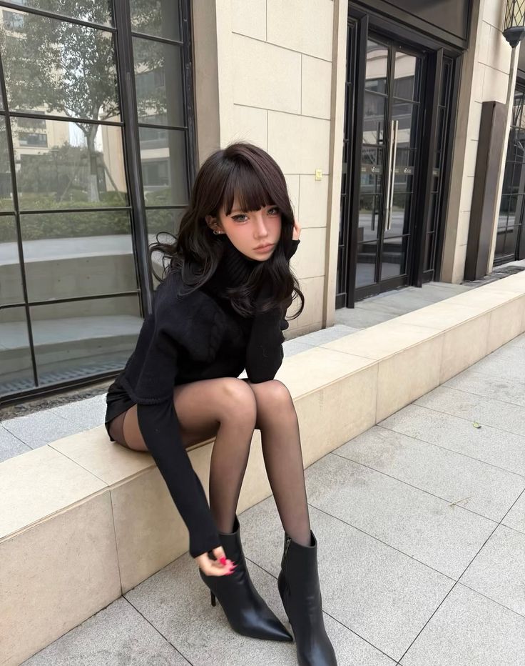 Woman in a black turtleneck and tights sitting outdoors
