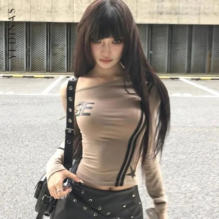Woman with long dark hair wearing a cropped top and black skirt outdoors