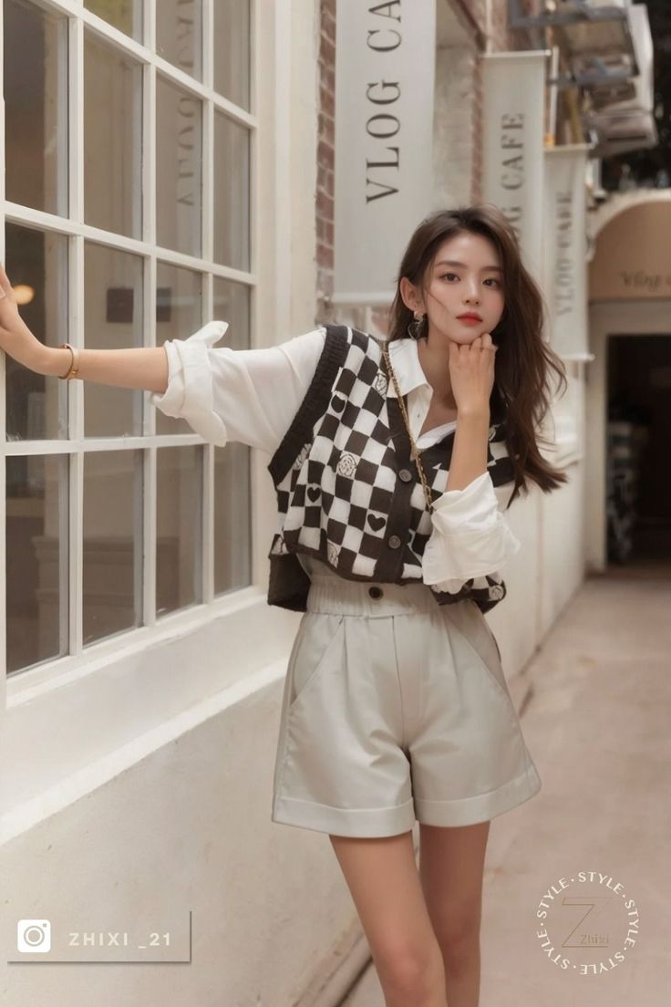 Woman in a checkered vest and shorts posing outdoors
