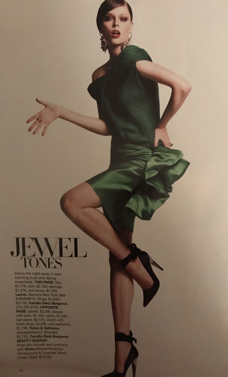 Woman in a green dress and high heels posing in a studio