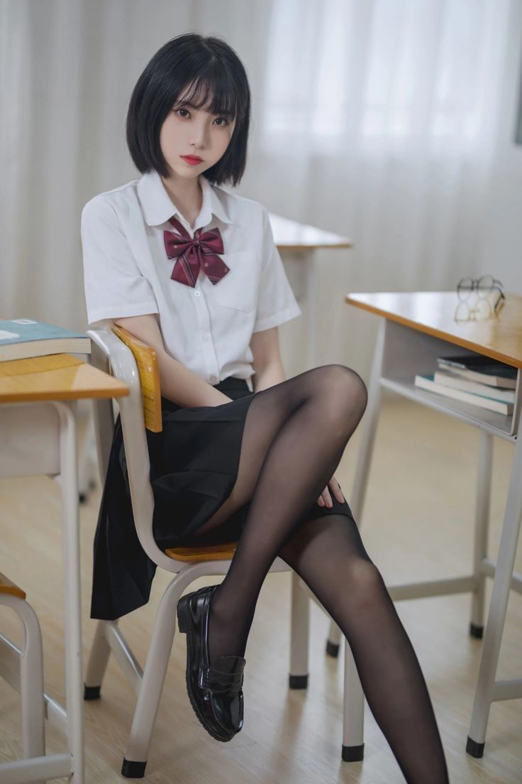 Young woman in a school uniform sitting in a classroom