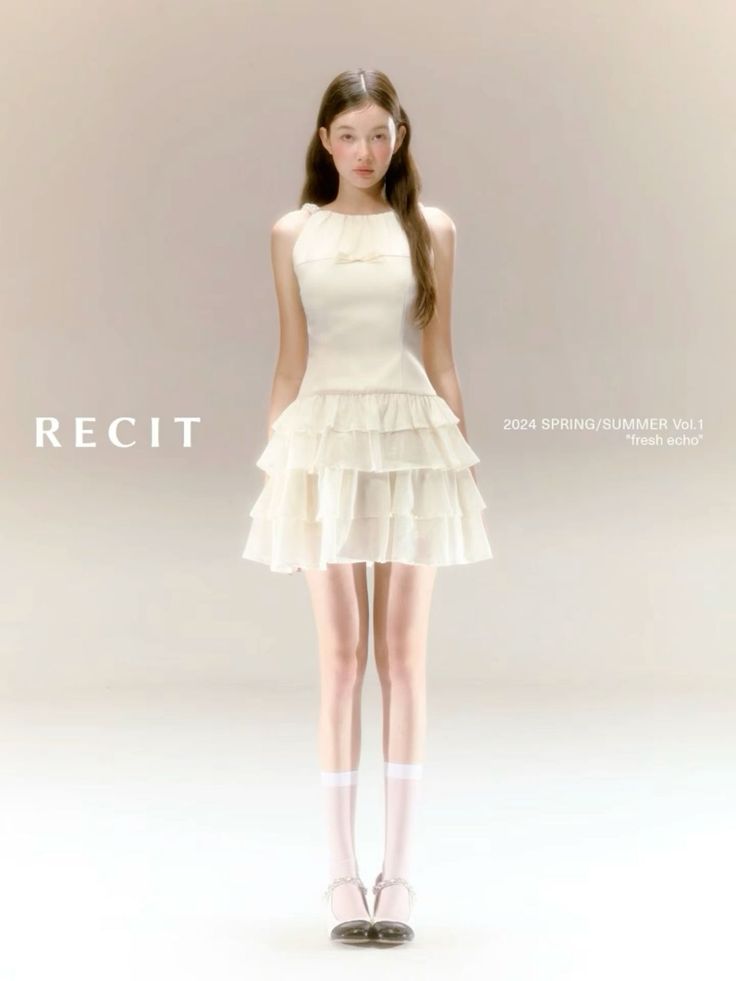 Woman in a white ruffle dress and white socks standing against a light background