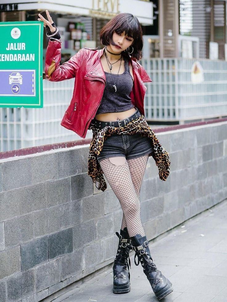 Woman in a red leather jacket and fishnet stockings posing outdoors