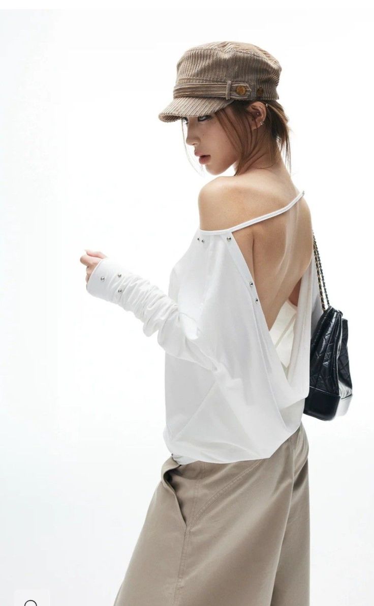 Woman in a corduroy hat and off-shoulder top with an exposed back