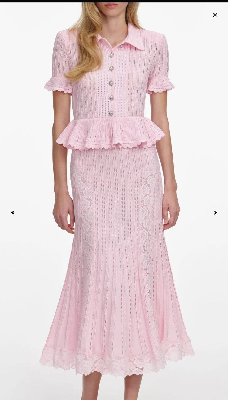 Woman in a pink knitted dress with lace details and a peplum top