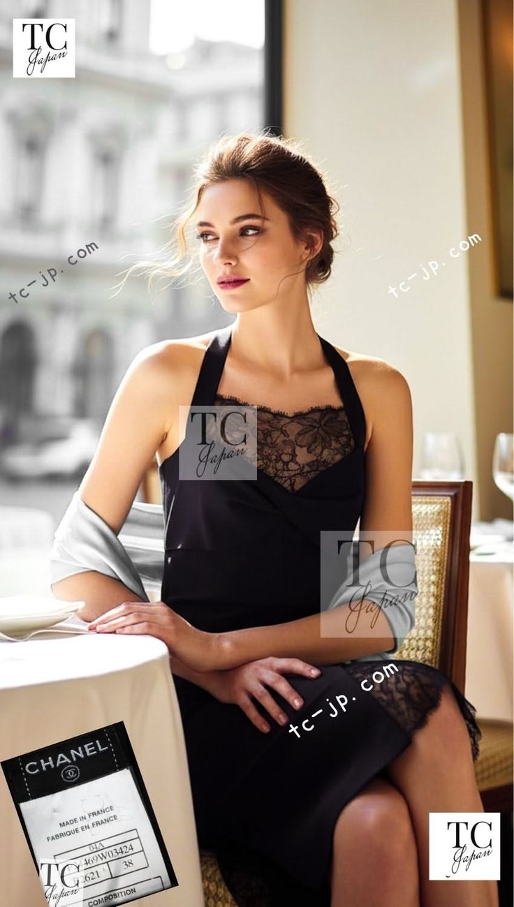 Woman in a black dress with lace trim sitting at a table indoors
