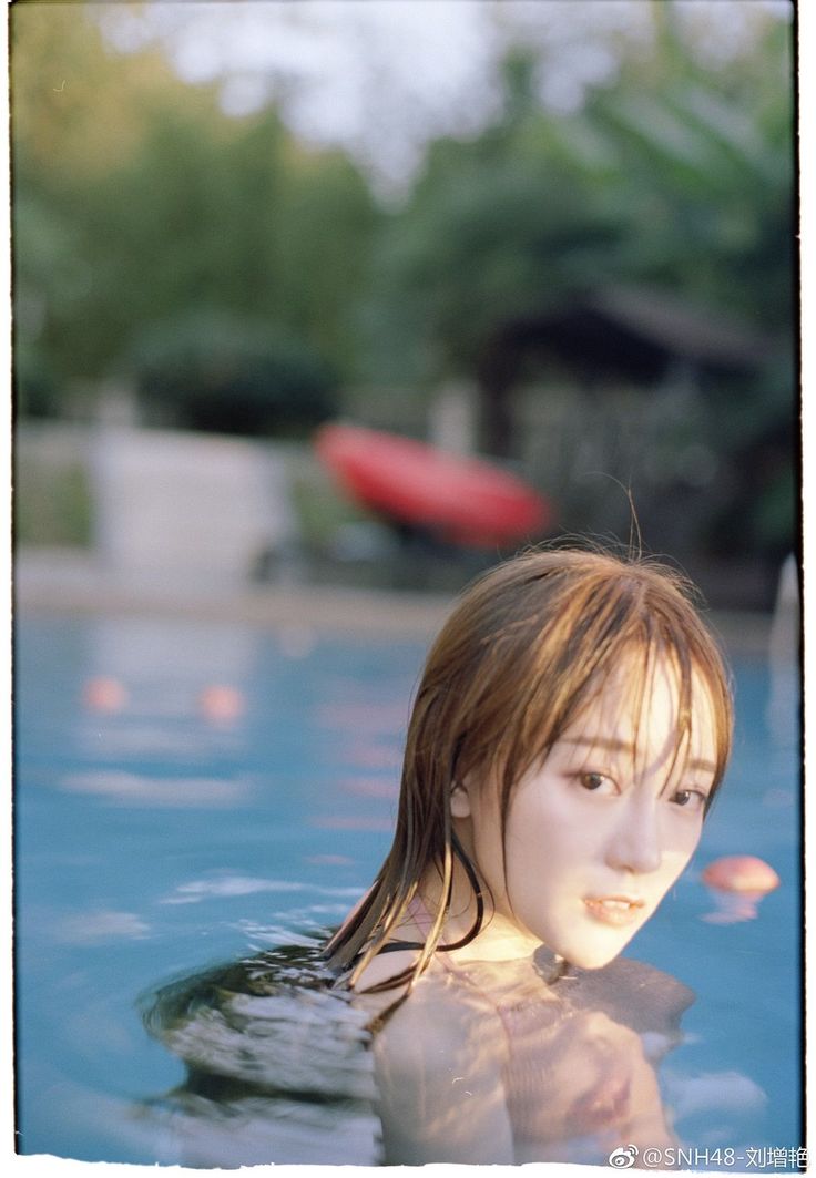 Woman with wet hair in a swimming pool with soft lighting