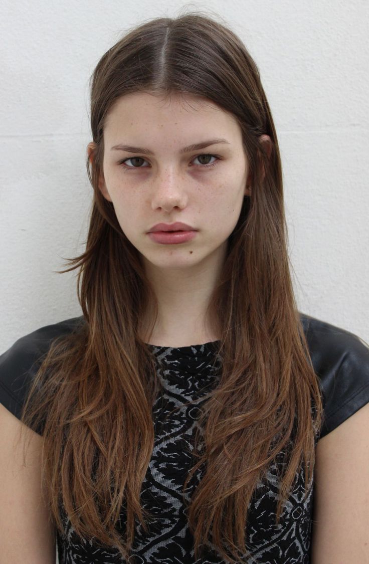 Woman with long brown hair and freckles wearing a black patterned top