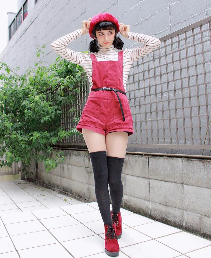 Woman in a red beret and overalls with thigh high socks outdoors