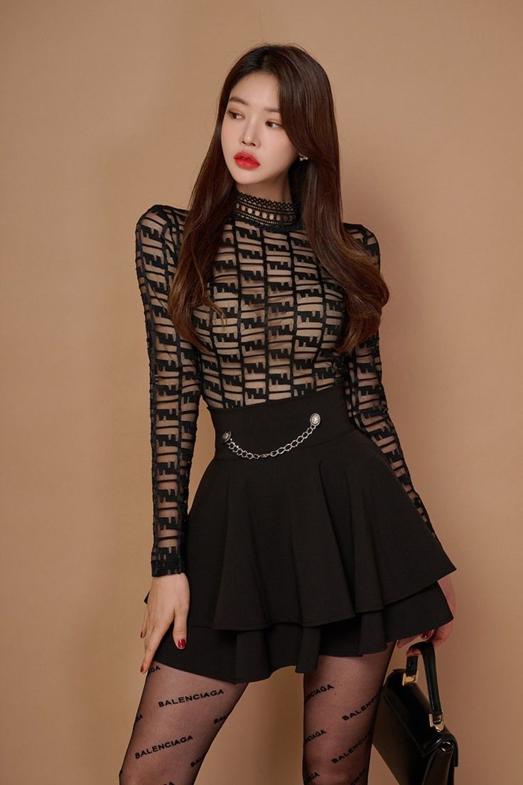 Woman in a sheer black top and short skirt with a chain belt