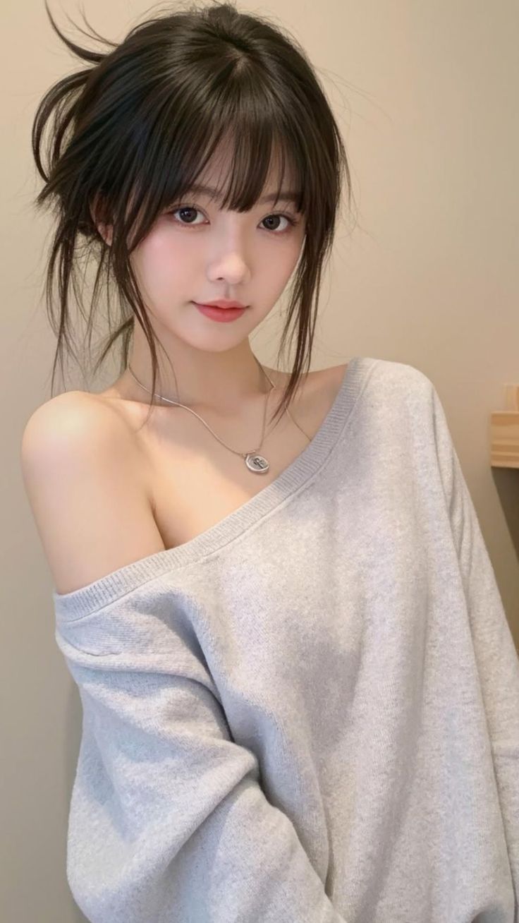 Woman with black hair in an off-shoulder sweater and silver necklace