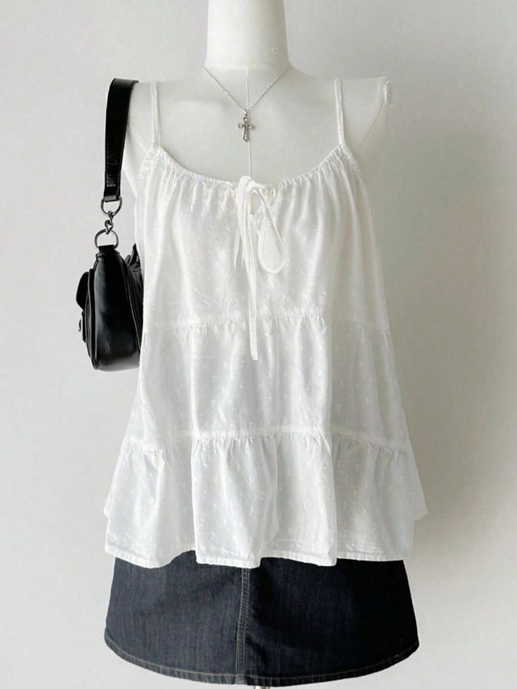 White tiered top and denim skirt on a mannequin with a cross necklace and black bag
