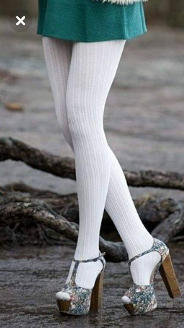 Person wearing white ribbed tights and floral platform heels on wet ground
