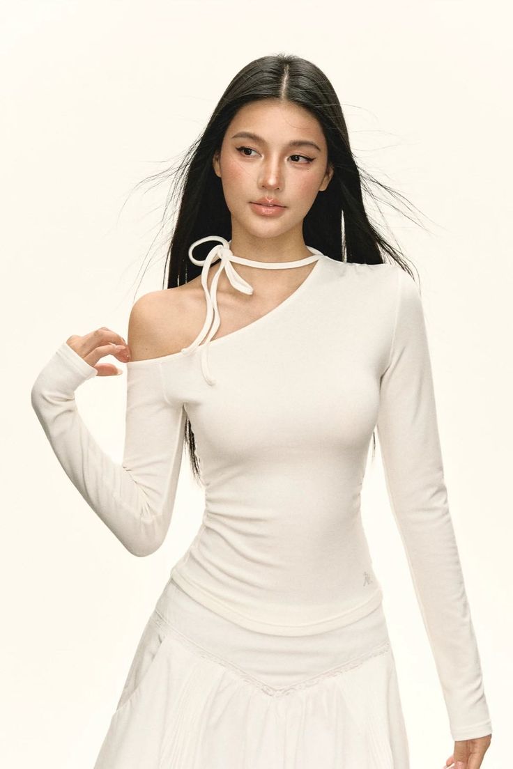 Woman with long black hair wearing a white off-shoulder top and choker
