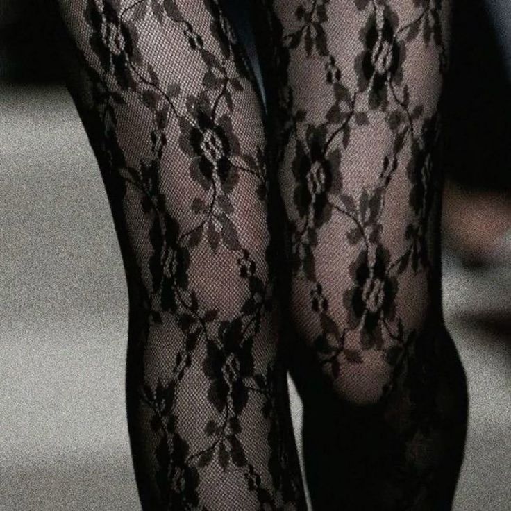 Close up of legs wearing black lace stockings with a floral pattern