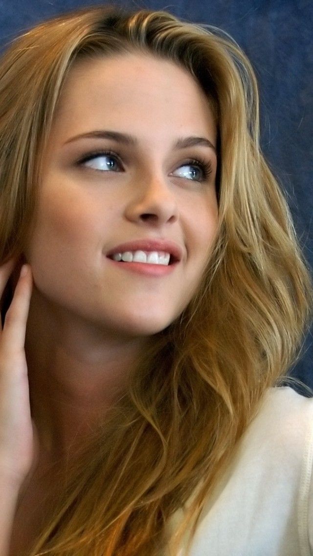 Woman with blonde hair and blue eyes smiling and looking up