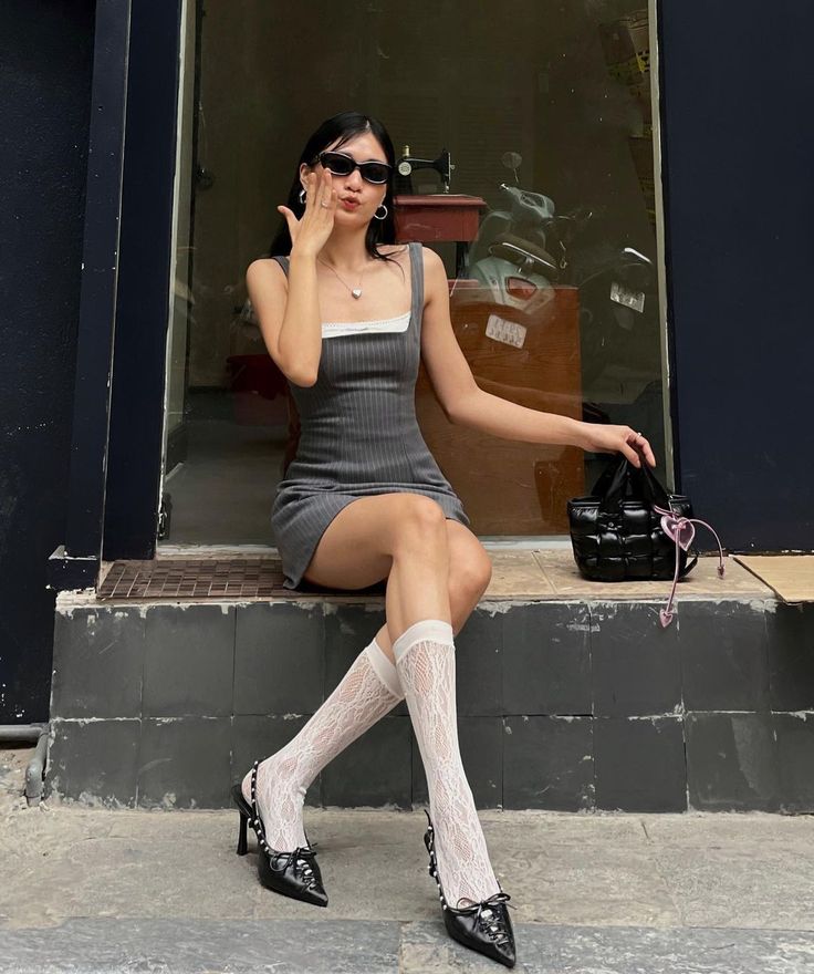 Woman in a mini dress and lace socks sitting outdoors