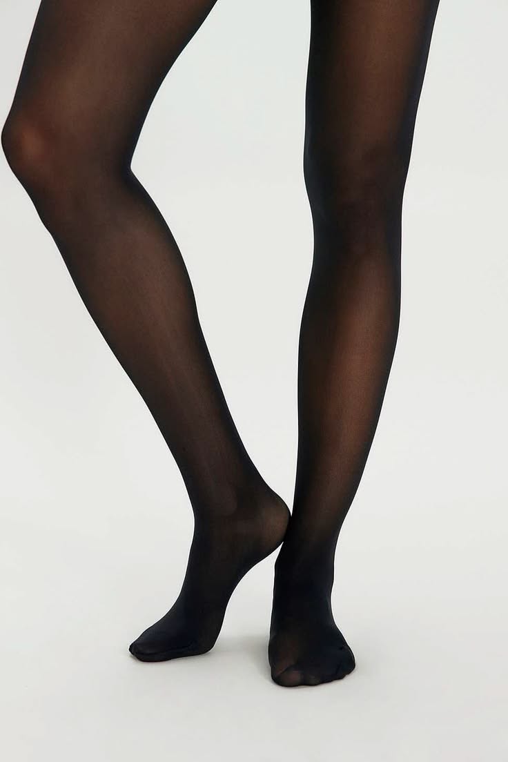 Person wearing black tights against a white background