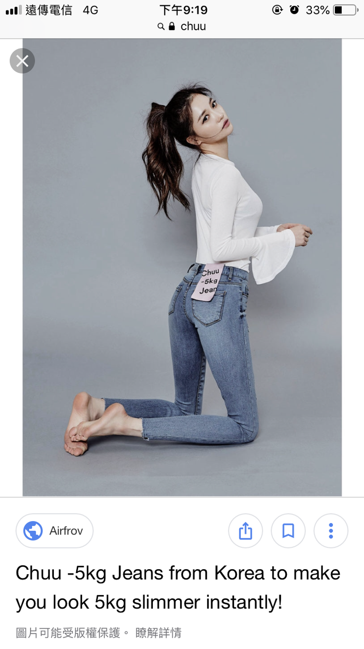 Woman in skinny jeans and a white long-sleeve shirt kneeling in a studio