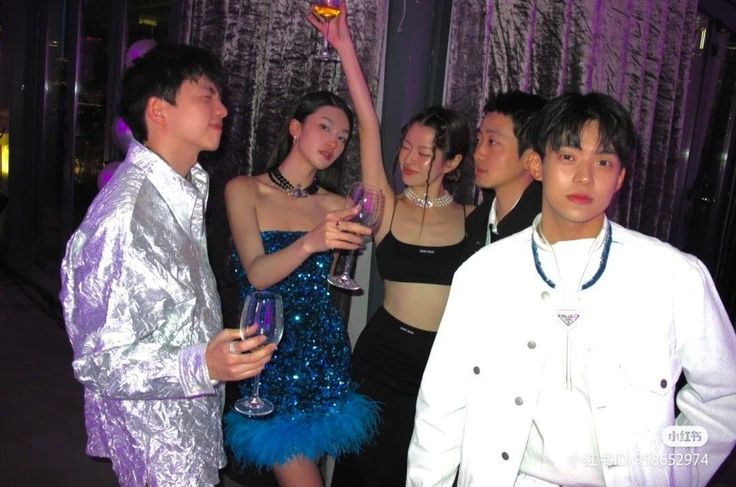 Group of people at a party with wine glasses and dark lighting