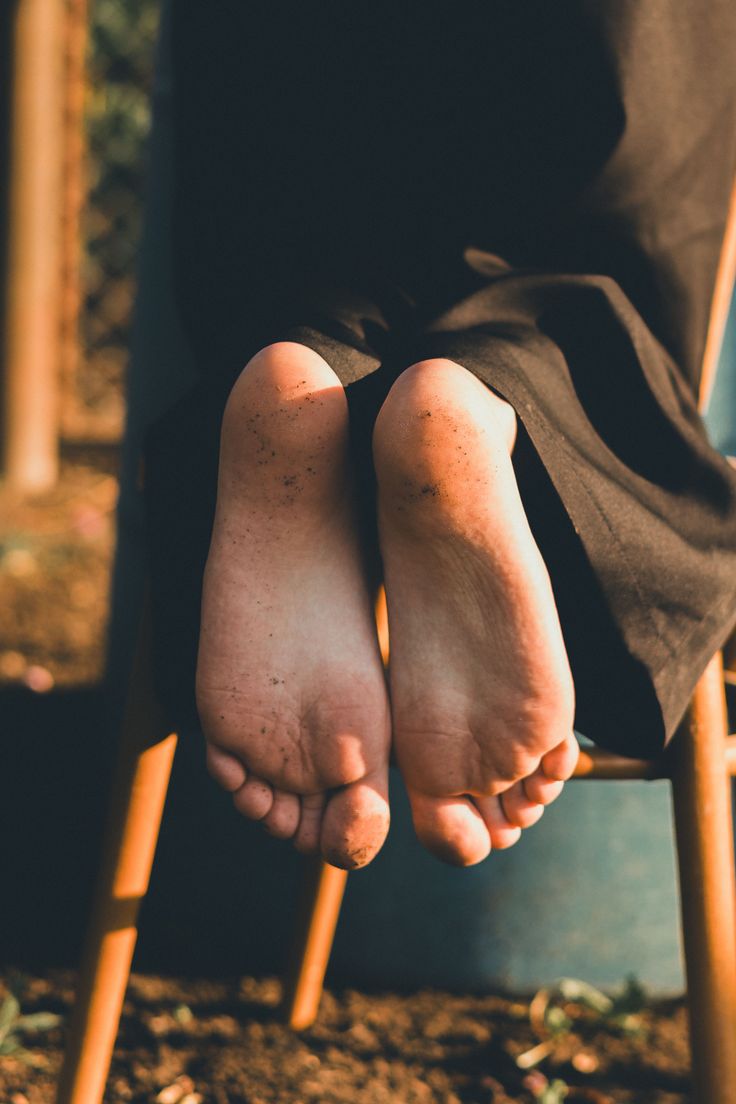 Bare feet with dirt on them, illuminated by golden hour light