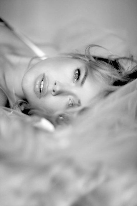 Woman with long hair lying down, looking up at the camera