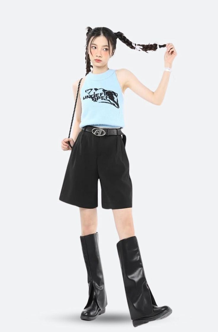 Woman with pigtails wearing a light blue top, black shorts, and black boots