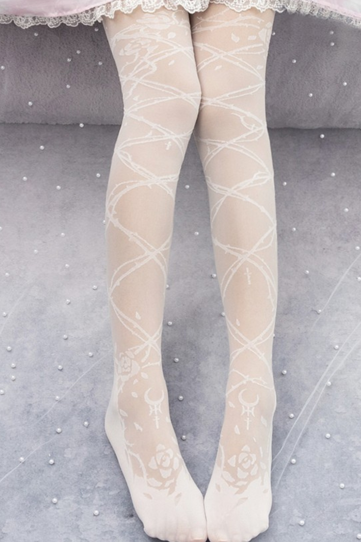 Legs in white tights with rose and cross patterns, lace trim visible