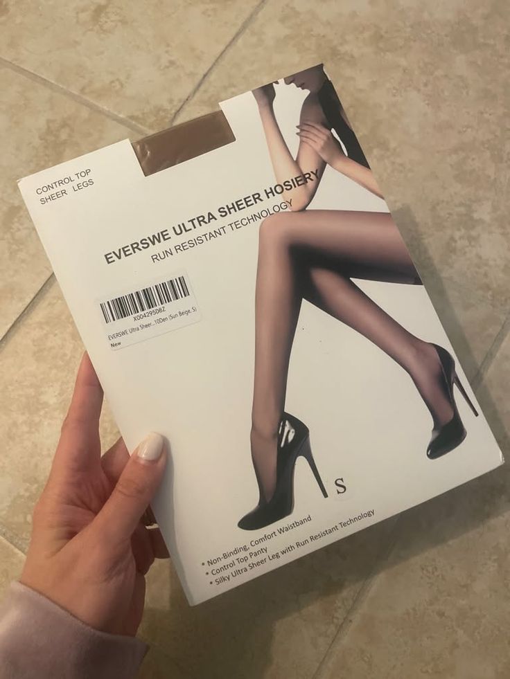 Hand holding a package of sheer hosiery with a model's legs in high heels