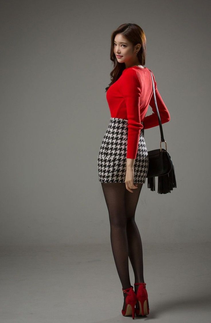 Woman in a red top and houndstooth skirt with black tights and red heels