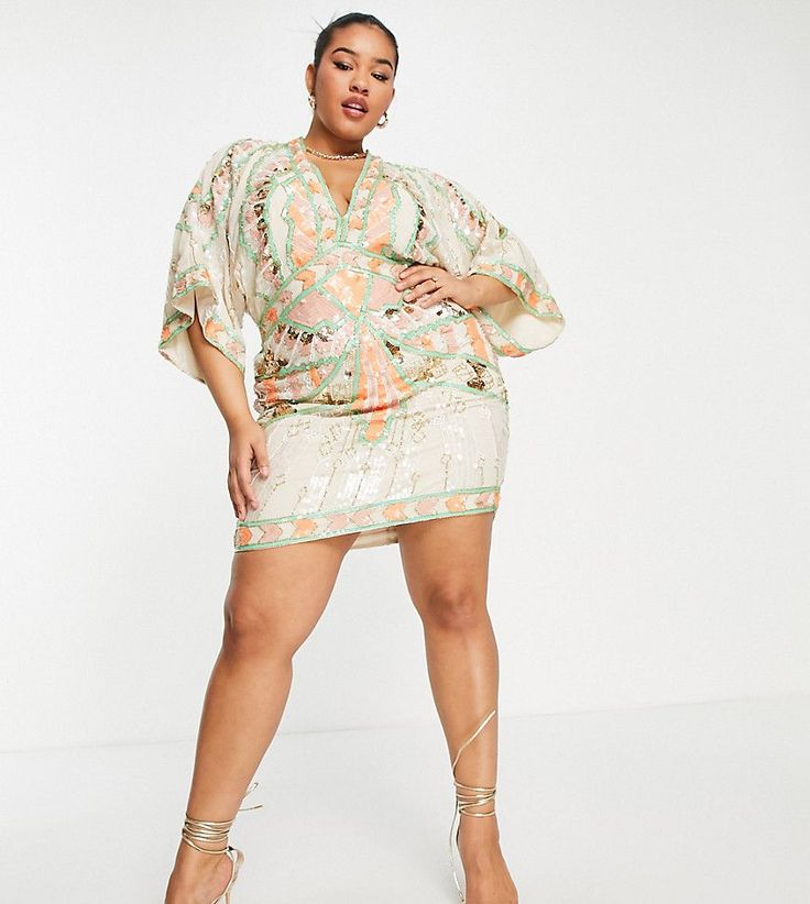 Woman in a sequined mini dress with kimono sleeves and high heels