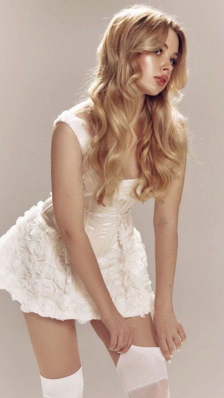 Woman with blonde hair in a white dress and thigh-high socks