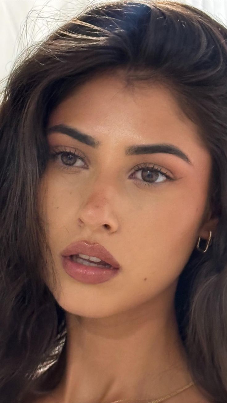 Close up portrait of a woman with dark hair and glossy lips
