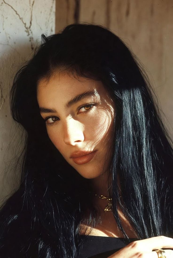 Woman with long black hair and dramatic lighting on her face