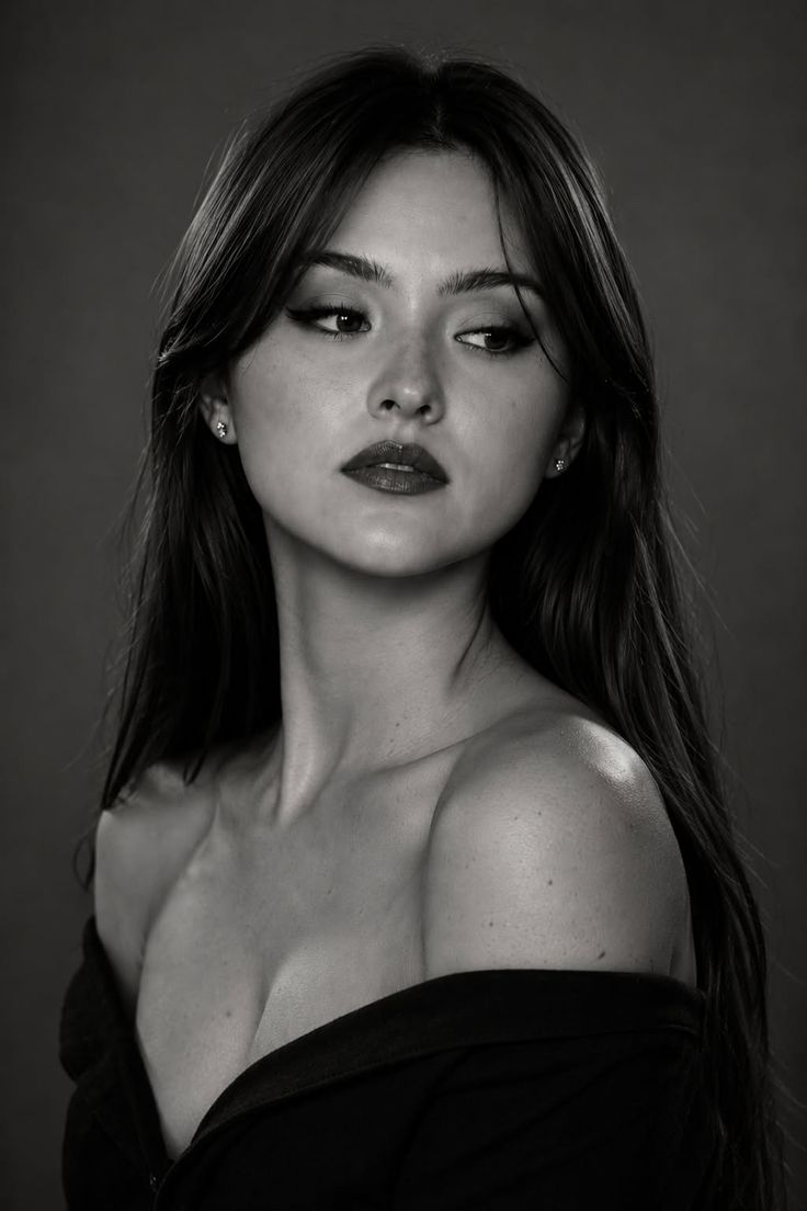 Woman with long hair and red lipstick wearing an off-shoulder top